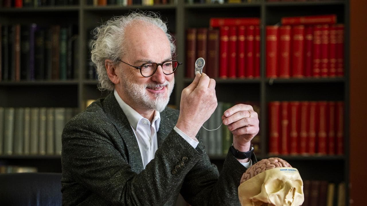 Professor Mark Cook demonstrating an epilepsy monitoring device with a brain model